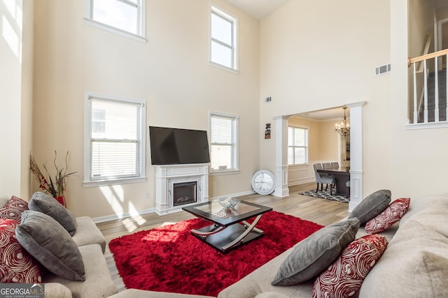 3450 Long Lake Dr, Douglasville, GA 30135 - living area with a chandelier, visible vents, ornate columns, and wood finished floors