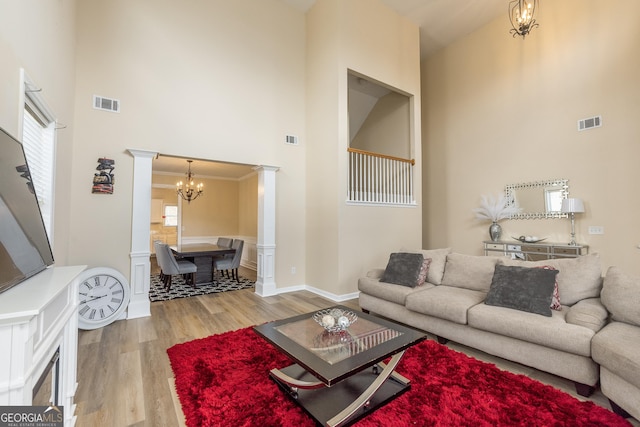3450 Long Lake Dr, Douglasville, GA 30135 - living area with visible vents, a notable chandelier, light wood-style floors, ornate columns, and a towering ceiling