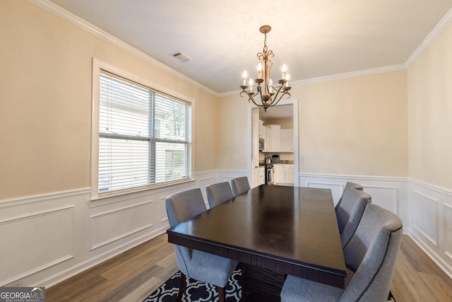 3450 Long Lake Dr, Douglasville, GA 30135 - dining room featuring a chandelier, wood finished floors, visible vents, and a wainscoted wall