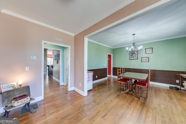 dining room featuring ornamental molding, a notable chandelier, and wood finished floors