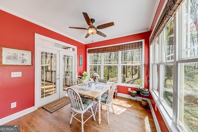 sunroom / solarium with baseboards, french doors, wood finished floors, and plenty of natural light