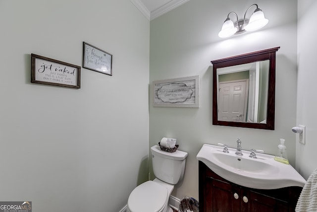 bathroom with toilet, vanity, and ornamental molding