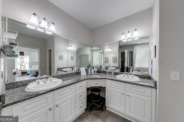 full bathroom featuring a stall shower, a sink, double vanity, and ensuite bathroom