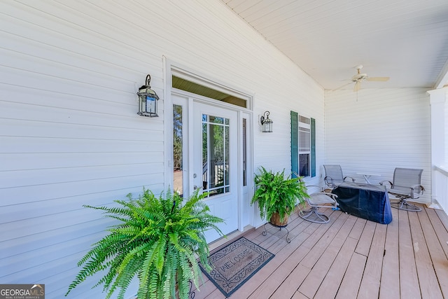 wooden terrace with ceiling fan and covered porch