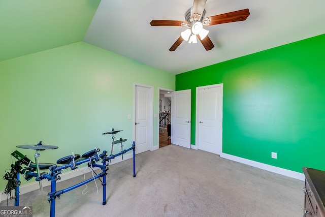 exercise area with baseboards, a ceiling fan, and vaulted ceiling