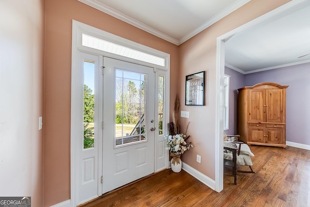 foyer entrance with wood finished floors, baseboards, and ornamental molding
