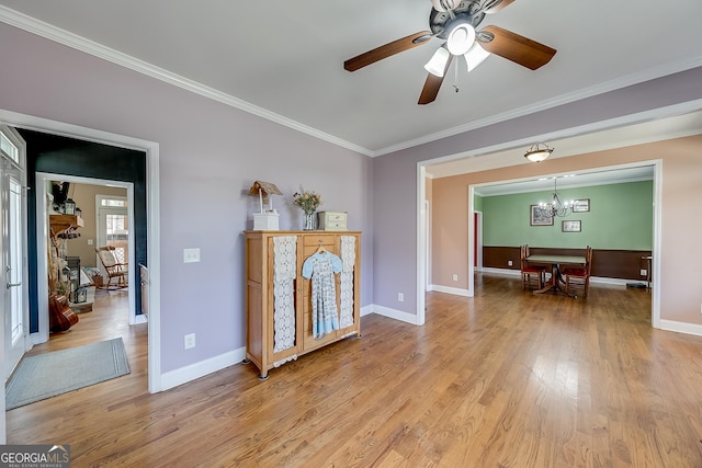 interior space with baseboards, crown molding, and light wood-style floors