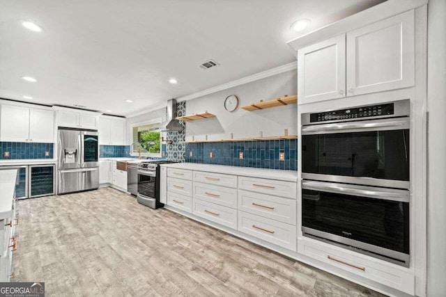 215 Collum St NW, Atlanta, GA 30314 - kitchen featuring light countertops, visible vents, crown molding, appliances with stainless steel finishes, and light wood-style floors
