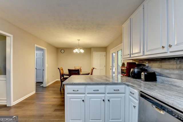 kitchen featuring a peninsula, dark wood-type flooring, dishwasher, a chandelier, and white cabinetry