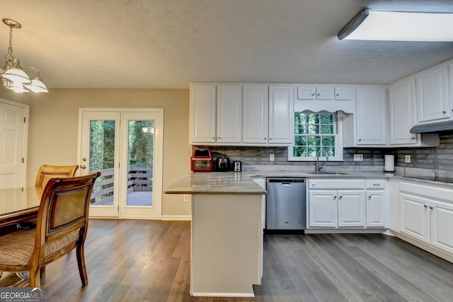 kitchen featuring white cabinetry, a peninsula, a sink, and dishwasher