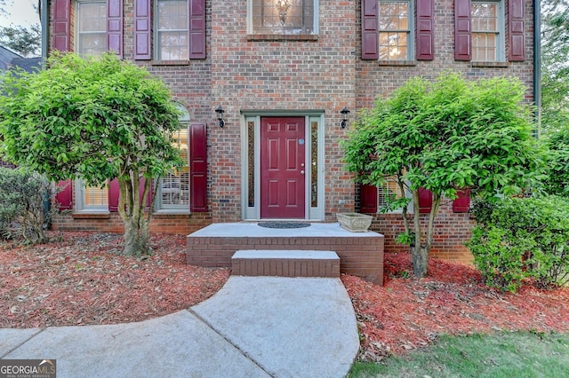 doorway to property featuring brick siding