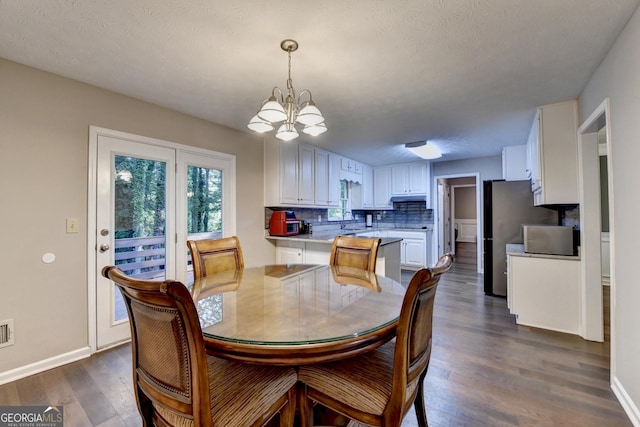 dining room with baseboards, a notable chandelier, dark wood finished floors, and visible vents