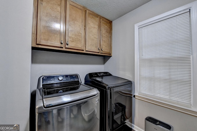 washroom featuring cabinet space, washer and clothes dryer, and baseboards