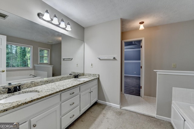 bathroom with a sink, double vanity, baseboards, and a bath