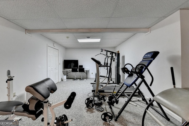 exercise area featuring carpet flooring, a drop ceiling, and baseboards