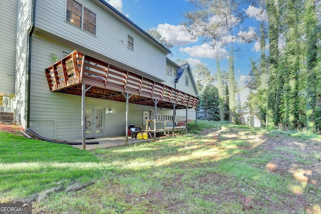 rear view of property with cooling unit, a deck, french doors, and a lawn