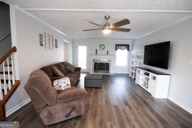 living area featuring dark wood-style floors, ornamental molding, and stairway