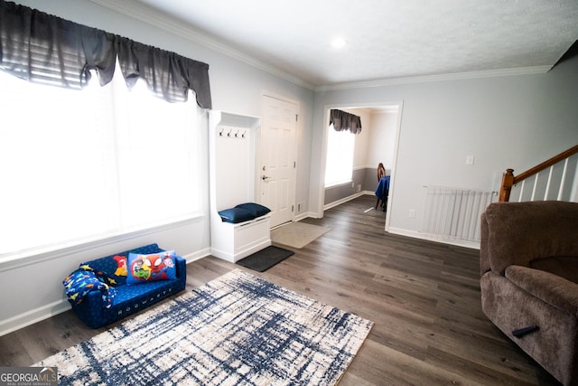 living area with baseboards, wood finished floors, and ornamental molding