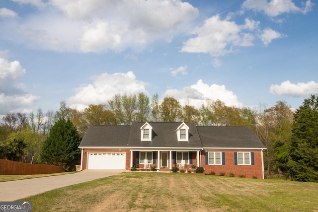 cape cod house featuring driveway, a front yard, covered porch, brick siding, and a garage