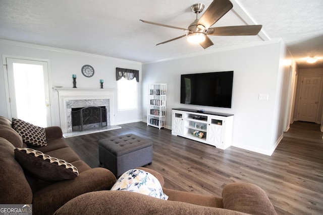 living area featuring baseboards, crown molding, wood finished floors, and a ceiling fan