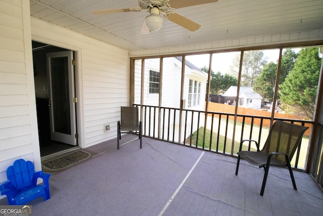 unfurnished sunroom featuring ceiling fan