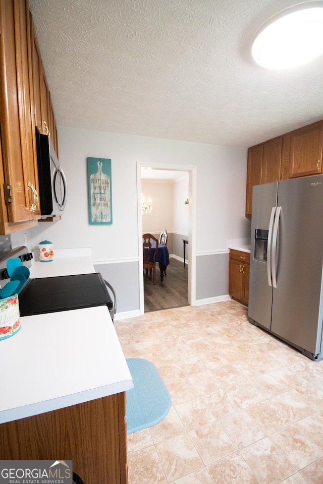 kitchen featuring light countertops, brown cabinets, and appliances with stainless steel finishes