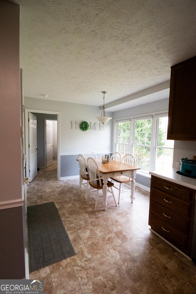 unfurnished dining area with baseboards and a textured ceiling