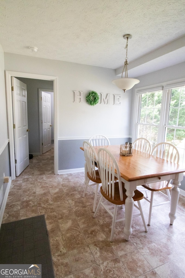 dining area with baseboards and a textured ceiling