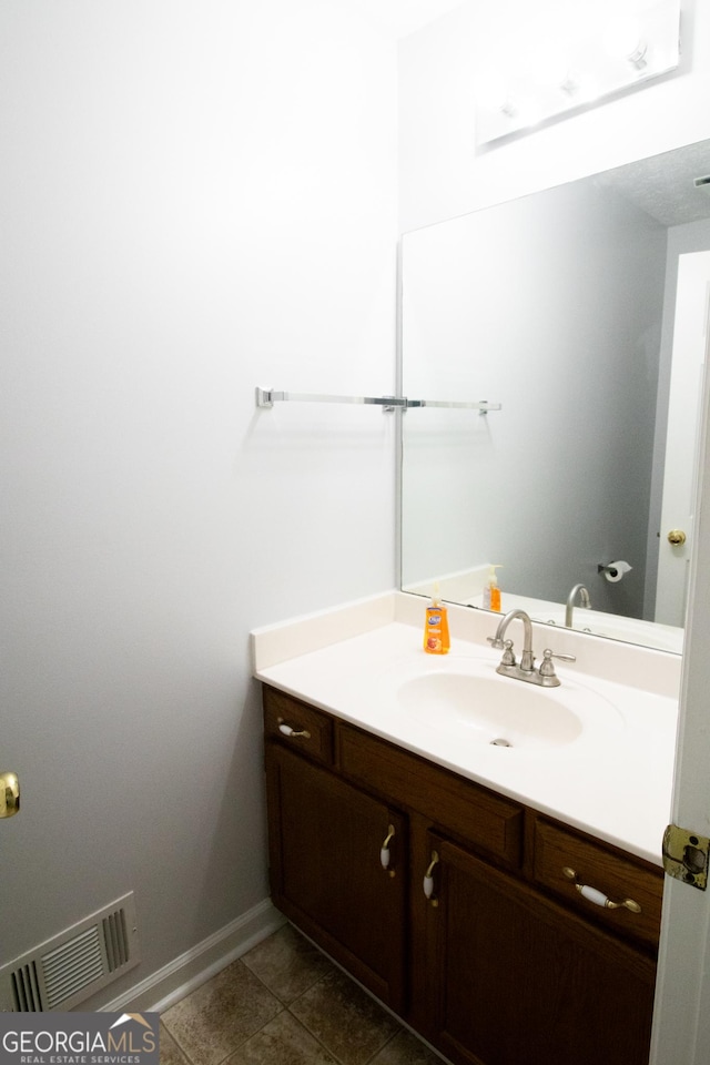 bathroom featuring tile patterned floors, vanity, baseboards, and visible vents
