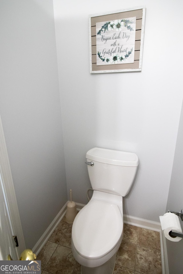 bathroom featuring baseboards, toilet, and tile patterned floors