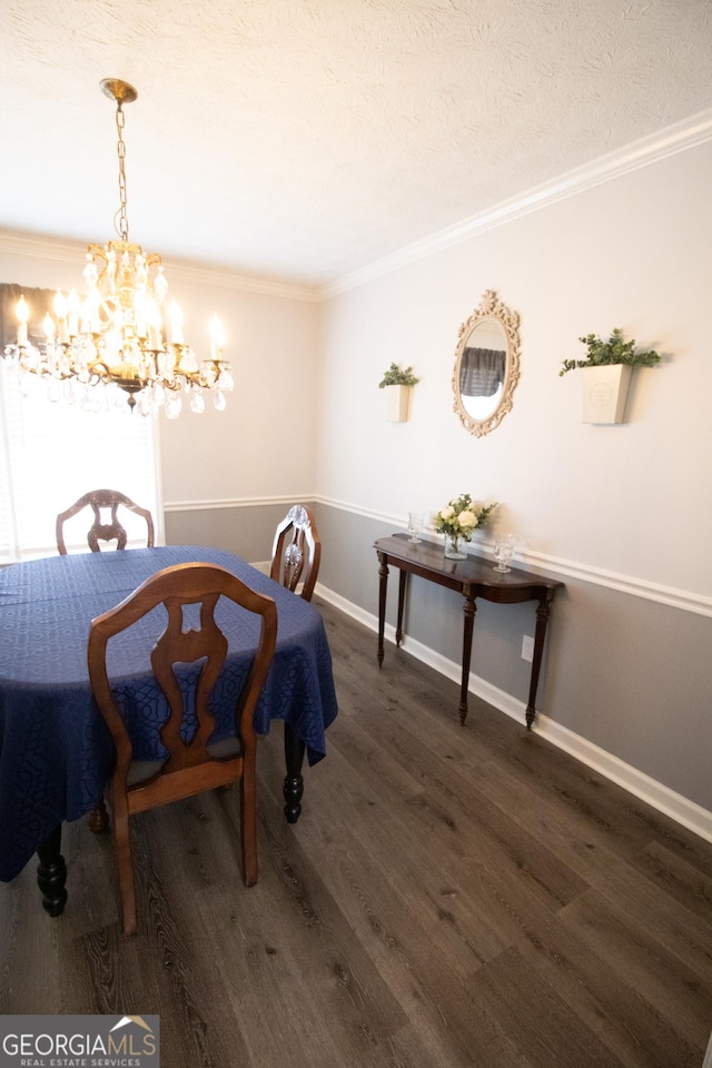 dining area with a textured ceiling, wood finished floors, ornamental molding, and a chandelier