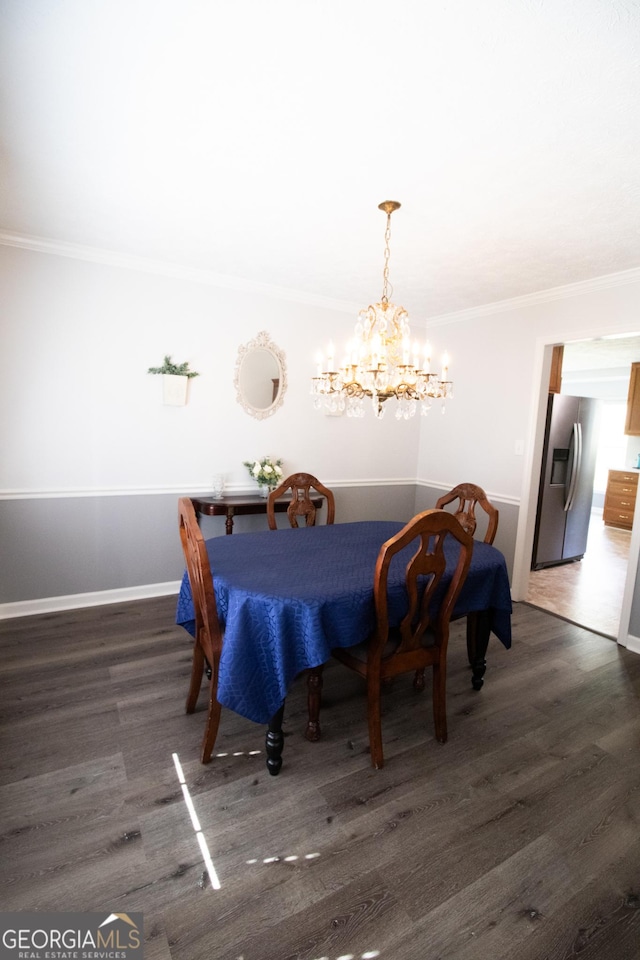dining space with baseboards, ornamental molding, wood finished floors, and a chandelier