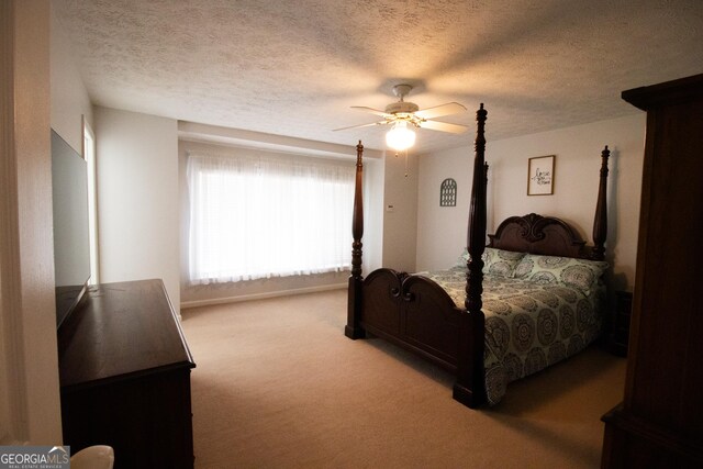 bedroom featuring a ceiling fan, carpet, and a textured ceiling