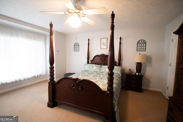 bedroom featuring baseboards, a textured ceiling, a ceiling fan, and light carpet