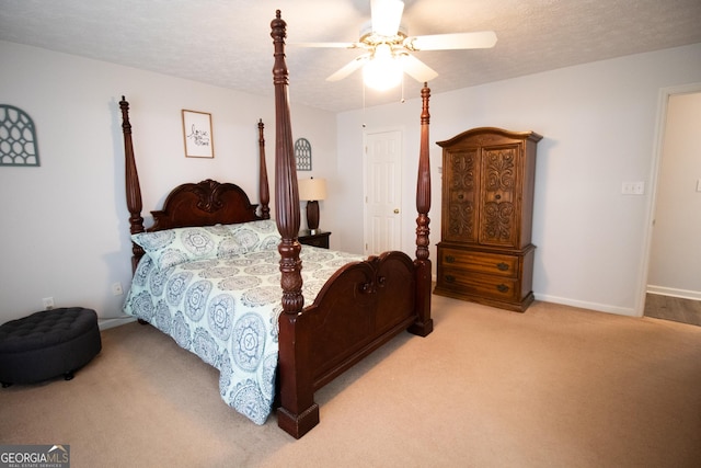 bedroom with ceiling fan, baseboards, light colored carpet, and a textured ceiling
