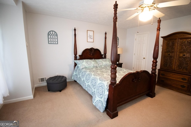 bedroom featuring baseboards, visible vents, a ceiling fan, and light carpet