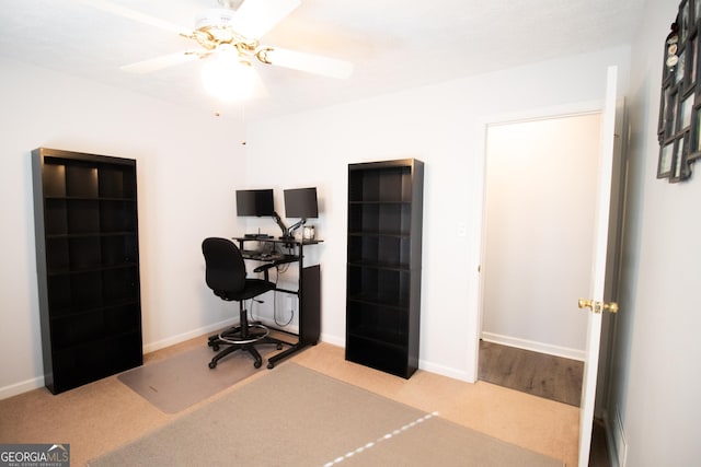 carpeted office with baseboards and a ceiling fan