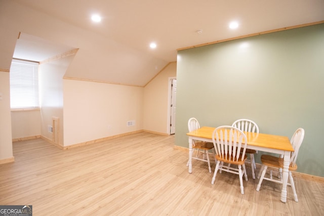 dining area featuring visible vents, baseboards, vaulted ceiling, and wood finished floors