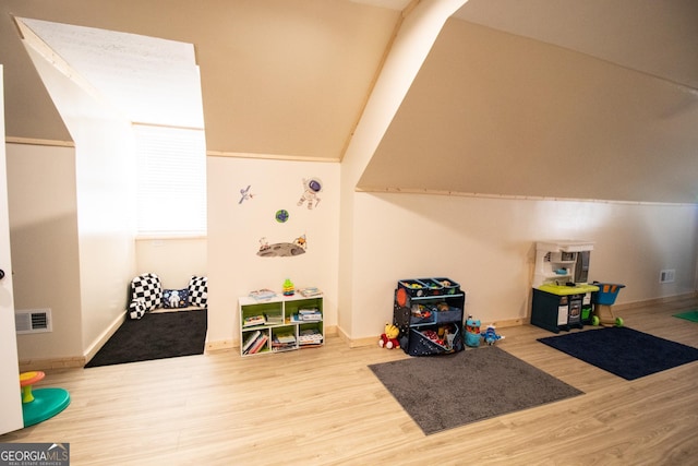 recreation room with baseboards, visible vents, and wood finished floors