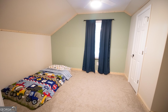 carpeted bedroom with baseboards, vaulted ceiling, and a ceiling fan