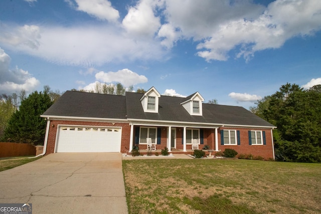 new england style home featuring an attached garage, concrete driveway, brick siding, a front lawn, and covered porch