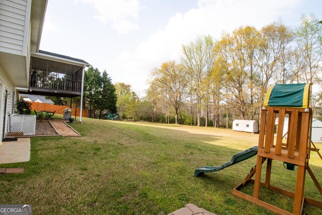 view of yard featuring a playground and an outbuilding