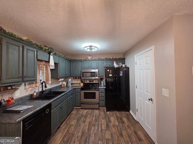 181 King St, Clermont, GA 30527 - kitchen featuring black appliances, a sink, dark countertops, dark wood-style floors, and a textured ceiling