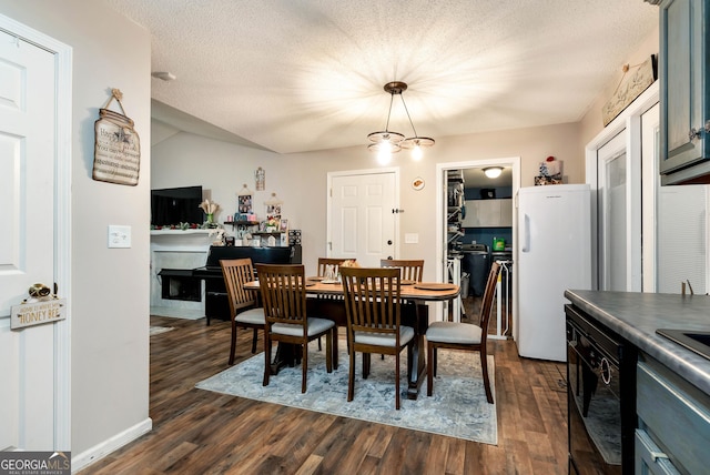 181 King St, Clermont, GA 30527 - dining space featuring dark wood-style flooring, a textured ceiling, a fireplace, and a chandelier