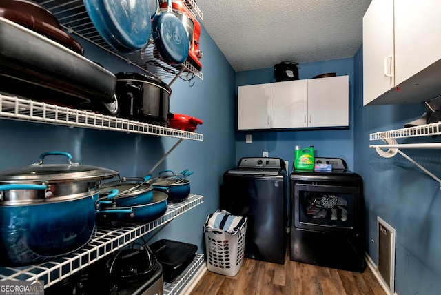 181 King St, Clermont, GA 30527 - laundry room featuring cabinet space, washer and dryer, wood finished floors, baseboards, and a textured ceiling