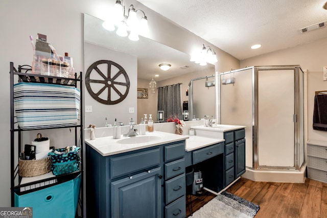 181 King St, Clermont, GA 30527 - full bath featuring wood finished floors, a stall shower, vanity, and a textured ceiling