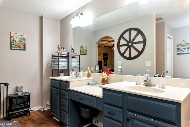 181 King St, Clermont, GA 30527 - bathroom with wood finished floors, double vanity, a ceiling fan, and a textured ceiling