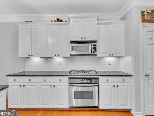 5454 Alanis Pl SE Unit 19, Mableton, GA 30126 - kitchen featuring appliances with stainless steel finishes, white cabinets, dark stone countertops, backsplash, and light wood finished floors