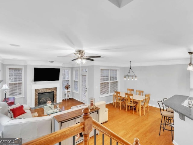 5454 Alanis Pl SE Unit 19, Mableton, GA 30126 - living room featuring a fireplace, ornamental molding, light wood-style flooring, and a ceiling fan