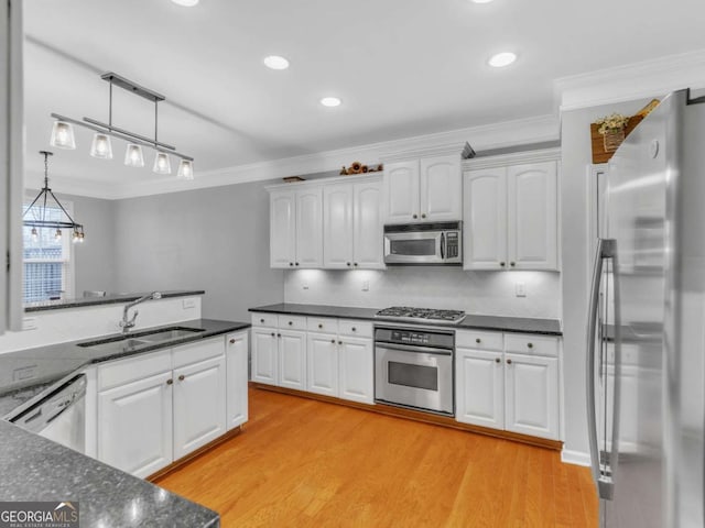 5454 Alanis Pl SE Unit 19, Mableton, GA 30126 - kitchen with stainless steel appliances, ornamental molding, white cabinets, light wood finished floors, and hanging light fixtures